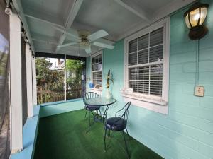 a porch with a table and chairs and a ceiling fan at Casita Margarita in Lanark Village
