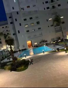 タンジェにあるApartment and family residence 2 bedrooms, poolsの夜間のスイミングプール付きの大きな建物