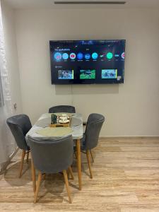 タンジェにあるApartment and family residence 2 bedrooms, poolsのダイニングルーム(椅子、壁掛けテレビ付)