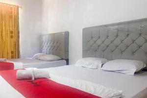 1 Schlafzimmer mit 2 Betten und einer roten Decke in der Unterkunft RedDoorz at Risma Hostel ITERA Lampung in Kedaton + 25 Fotos