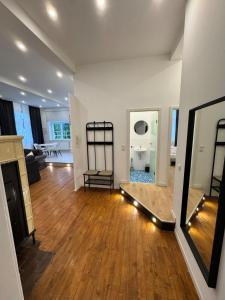 a living room with a hard wood floor and a mirror at Bavaria Home Modern Living in Geisenfeld