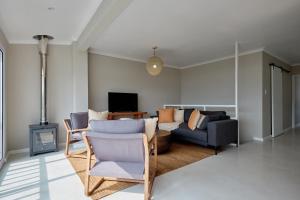 Una sala de estar con un sofá y un televisor. en Seaview Haven - Luxury Coastal Escape Simon's Town, en Simonʼs Town