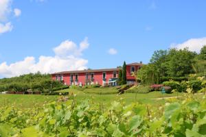ein rotes Gebäude in der Mitte eines Feldes in der Unterkunft Hôtel Restaurant La Montagne De Brancion in Martailly-lès-Brancion