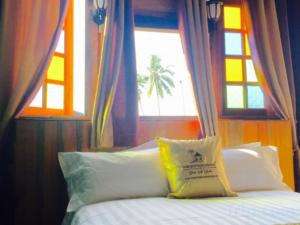 a bed with a yellow pillow in front of a window at Kampong Pinang Sebatang Melaka in Malacca +200 photos