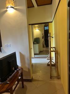 a living room with a tv on a table and a mirror at Dukuh Village Villas & Art in Tegalalang