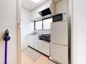 a kitchen with white cabinets and a refrigerator at Ikebukuro-Otsuka-10min ShinOtsuka Sta-For families and groups-Switch-net-Mobile Wi-Fi in Tokyo