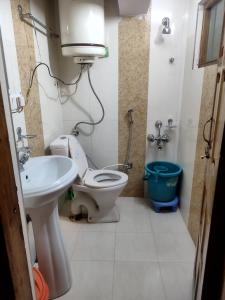 a bathroom with a toilet and a sink at Hotel Palestine in Pahalgām