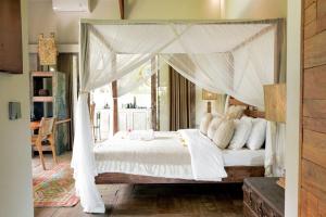 a bedroom with a white bed with a canopy at Villa Fleur in Tumbak Bayuh +71 photos