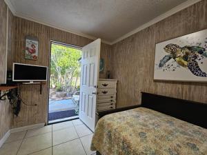 a bedroom with a bed and a television and a door at Villa Margarita in Lanark Village