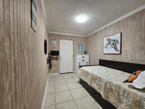 a bedroom with a bed and a dresser at Villa Margarita in Lanark Village