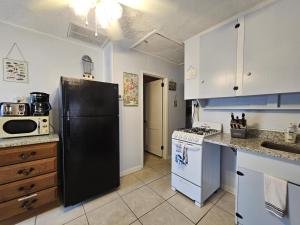 a kitchen with a black refrigerator and a stove at Villa Margarita in Lanark Village