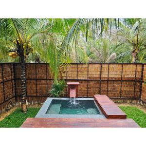 Ban Tha MaphraoにあるCheewatra Farmstay Coconut Houseの小さなスイミングプール(テーブル、フェンス付) +4枚の写真