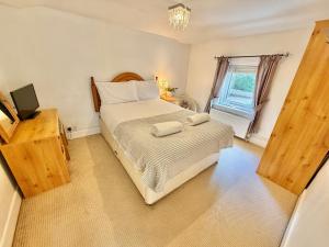 ein Schlafzimmer mit einem Bett mit zwei Handtüchern darauf in der Unterkunft Gateman's Cottage - Three Bedroom Detached Home - Free Parking - Close to New Forest and Beaches in West Moors