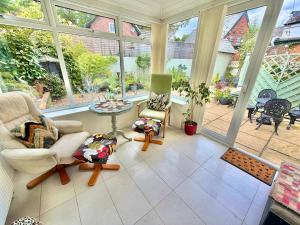 ein Wohnzimmer mit vielen Fenstern in der Unterkunft Gateman's Cottage - Three Bedroom Detached Home - Free Parking - Close to New Forest and Beaches in West Moors
