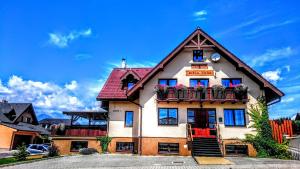 a large house with a red roof at Penzión Biela Voda in Veľká Lomnica