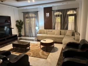 a living room with a couch and a tv at luxury dublex with private swimming pool in Obour