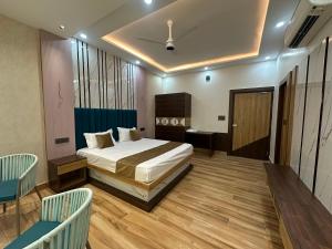 a bedroom with a bed and a table and chairs at Hotel Picnic Garden in Patna