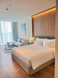 une chambre avec un grand lit et un salon dans l'établissement Little Kun - A La Carte Hạ Long Homestay view Biển, à Hạ Long