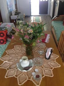 a table with a vase of flowers on a table at Eco Garten Guest House in Shkodër +45 photos