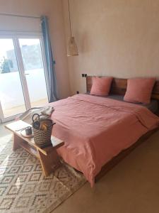 a bedroom with a bed with pink sheets and a window at Villa Face a l'océan- Havre de paix & grand confort avec piscine à TOUBAB DIALAW in Rufisque +34 photos