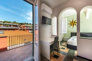 a bedroom with a desk and a bed and a balcony at La rosa dei venti in Santa Margherita Ligure