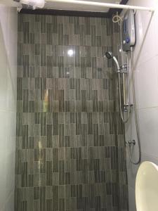 a shower in a bathroom with a tile floor at Libhu Hill Resort and Sports Complex in Maasin