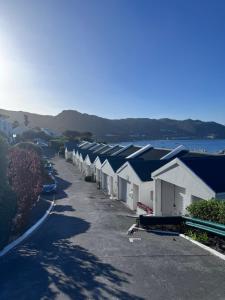 Una hilera de casas con una carretera y el agua. en Seaview Haven - Luxury Coastal Escape Simon's Town, en Simonʼs Town