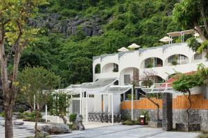een wit gebouw met een berg op de achtergrond bij One Day Tam Cốc Retreat in Ninh Binh