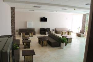 a living room with a couch and tables and a tv at DSK Hotel in Kranevo