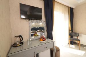 a room with a table with a television on a wall at BALPETEK HOTEL in Istanbul