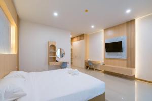 a hotel room with a white bed and a tv at Vera Residences Chiang Rai in Ban Nam Cham +39 photos