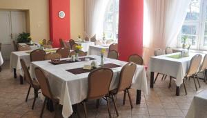 a dining room with white tables and chairs at Rezydencja Zamek in Krynica Zdrój