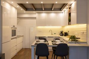 a kitchen with white cabinets and a table and chairs at The Monolith in Kalabaka