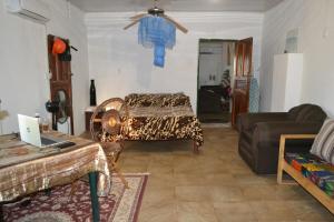 un salon avec un lit et un canapé dans l'établissement Kalibu Cottage offers you a cozy & private home for your holidays, à Livingstone