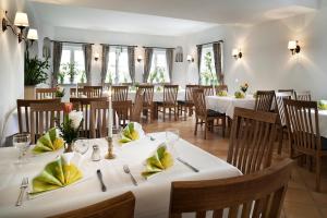 a dining room with white tables and chairs at Hotel Echinger Hof in Eching