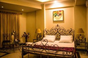 a bedroom with a bed with a wrought iron bed frame at Kohinoor Hotel in Dargai