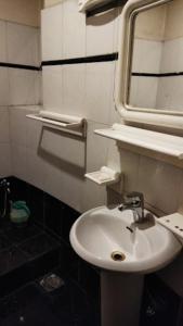 a bathroom with a sink and a mirror at Kohinoor Hotel in Dargai