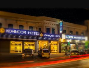 a hotel with cars parked in front of it at night at Kohinoor Hotel in Dargai