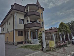 a yellow and white house with a fence at Helena Hostels in Kostinbrod