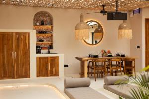 un salon avec une table et une salle à manger dans l'établissement Kaind - Luxury 4BR Villa with Private Pool and Outdoor Cinema on Gili Trawangan, à Gili Trawangan