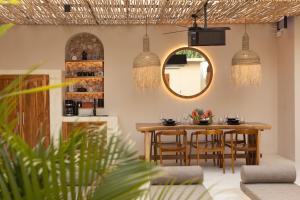 une salle à manger avec une table, des chaises et un miroir dans l'établissement Kaind - Luxury 4BR Villa with Private Pool and Outdoor Cinema on Gili Trawangan, à Gili Trawangan