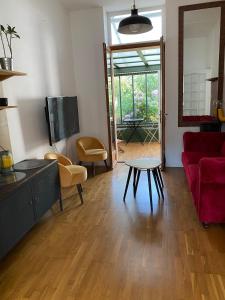 ein Wohnzimmer mit einem roten Sofa und einem Tisch in der Unterkunft La charmante petite maison in Croix