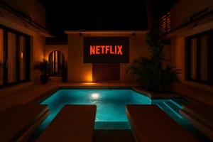 une piscine avec un panneau indiquant Netflix dans l'établissement Kaind - Luxury 4BR Villa with Private Pool and Outdoor Cinema on Gili Trawangan, à Gili Trawangan