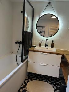 a bathroom with a sink and a mirror and a tub at La charmante petite maison in Croix +21 photos