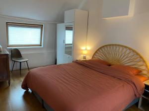 a bedroom with a large bed and a chair at La charmante petite maison in Croix
