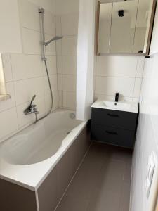 a white bathroom with a tub and a sink at Ferienwohnung in Bahnhofsnähe in Ludwigslust