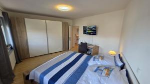 a bedroom with a bed and a tv on the wall at Perfect Living in Petersberg