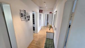 a hallway with white walls and wood floors and a hallway with white walls at Perfect Living in Petersberg +10 photos