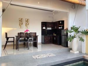 une salle à manger et une cuisine avec une table et des chaises dans l'établissement Villa Lestari by MentariPro Bali, à Lovina
