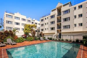 una piscina frente a dos edificios de apartamentos en Windbourne Unit 11, 101 The Esplanade, Golden Beac, en Golden Beach